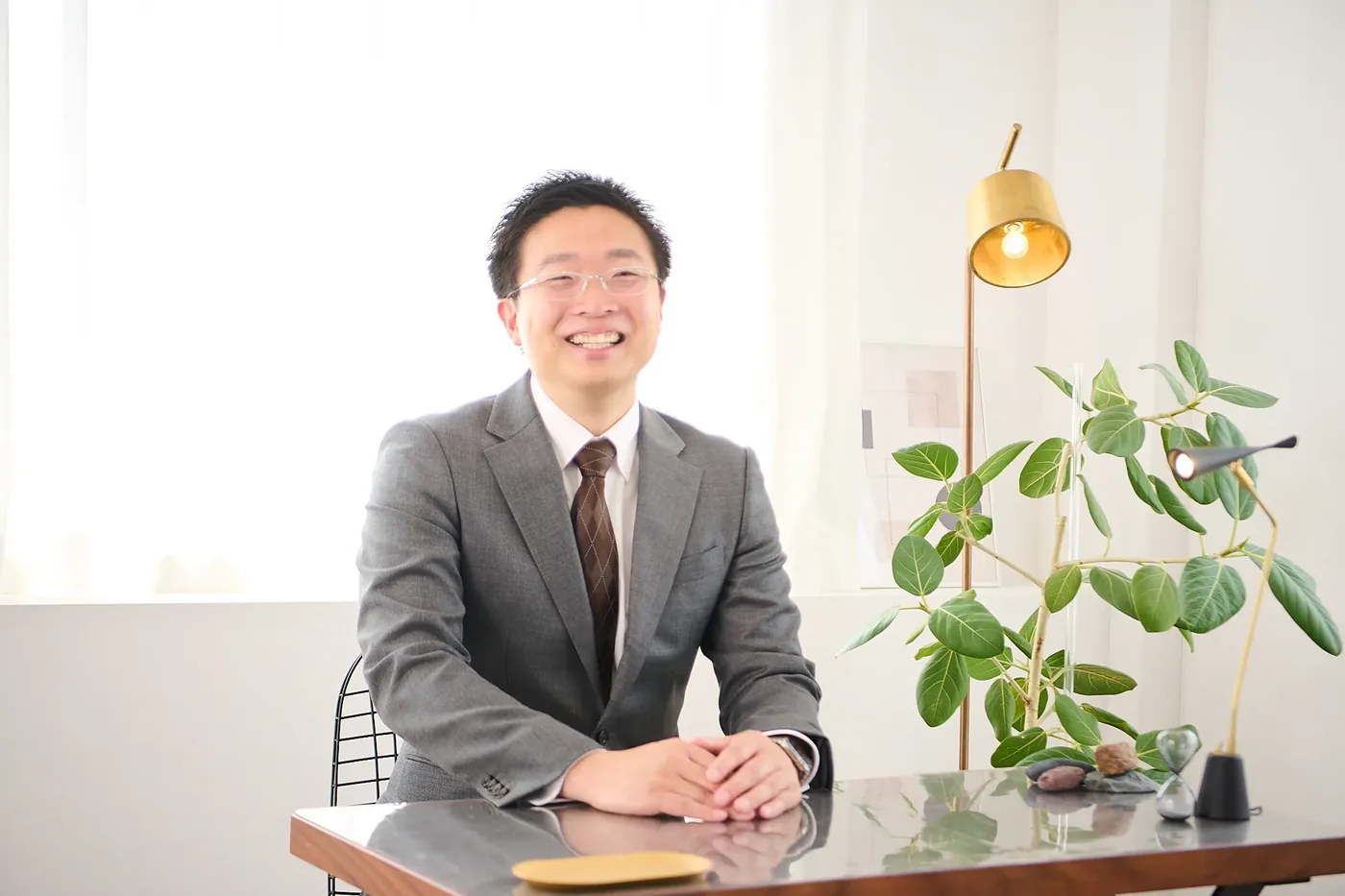 笑顔で座る丹沢祐介